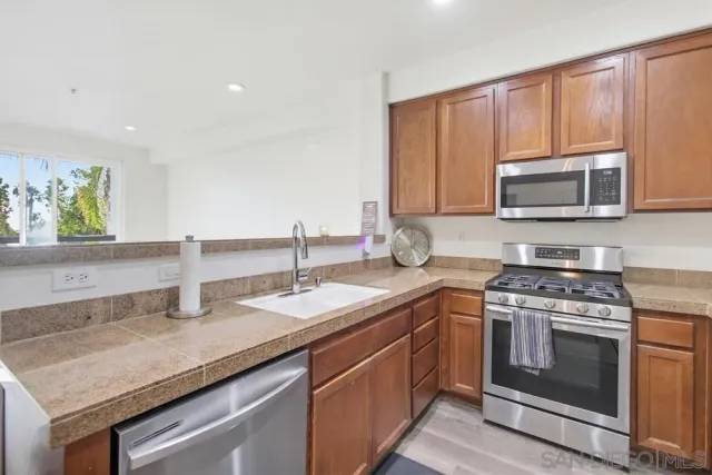 a kitchen with granite countertop a sink stove and microwave