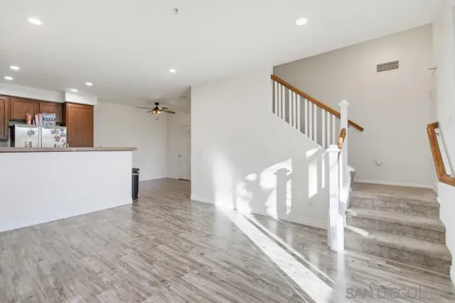 a view of a hallway with wooden floor and staircase