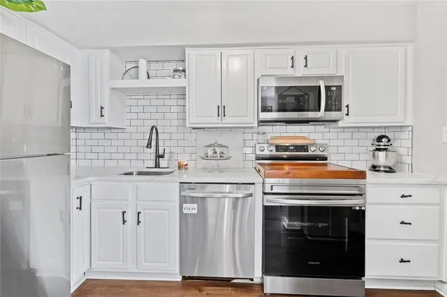 a kitchen with cabinets stainless steel appliances and sink