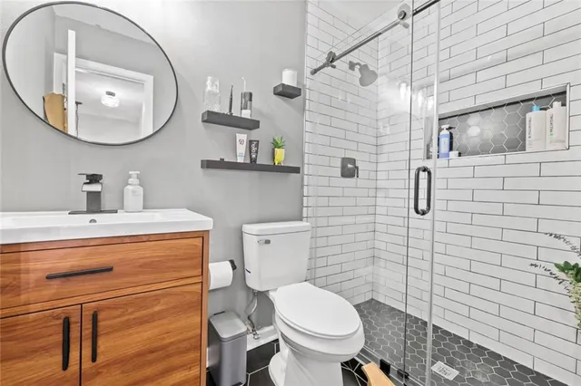 a bathroom with a toilet sink vanity and mirror