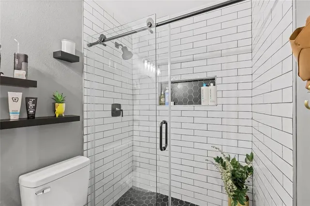 a bathroom with a toilet and a shower