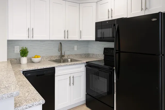 a kitchen with a sink a refrigerator and cabinets