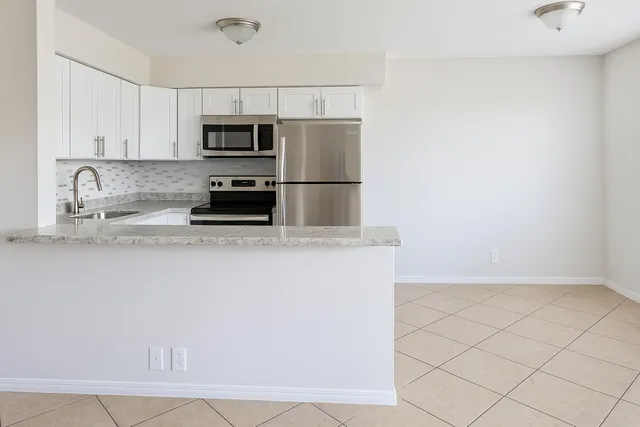 a kitchen with granite countertop a refrigerator and a sink