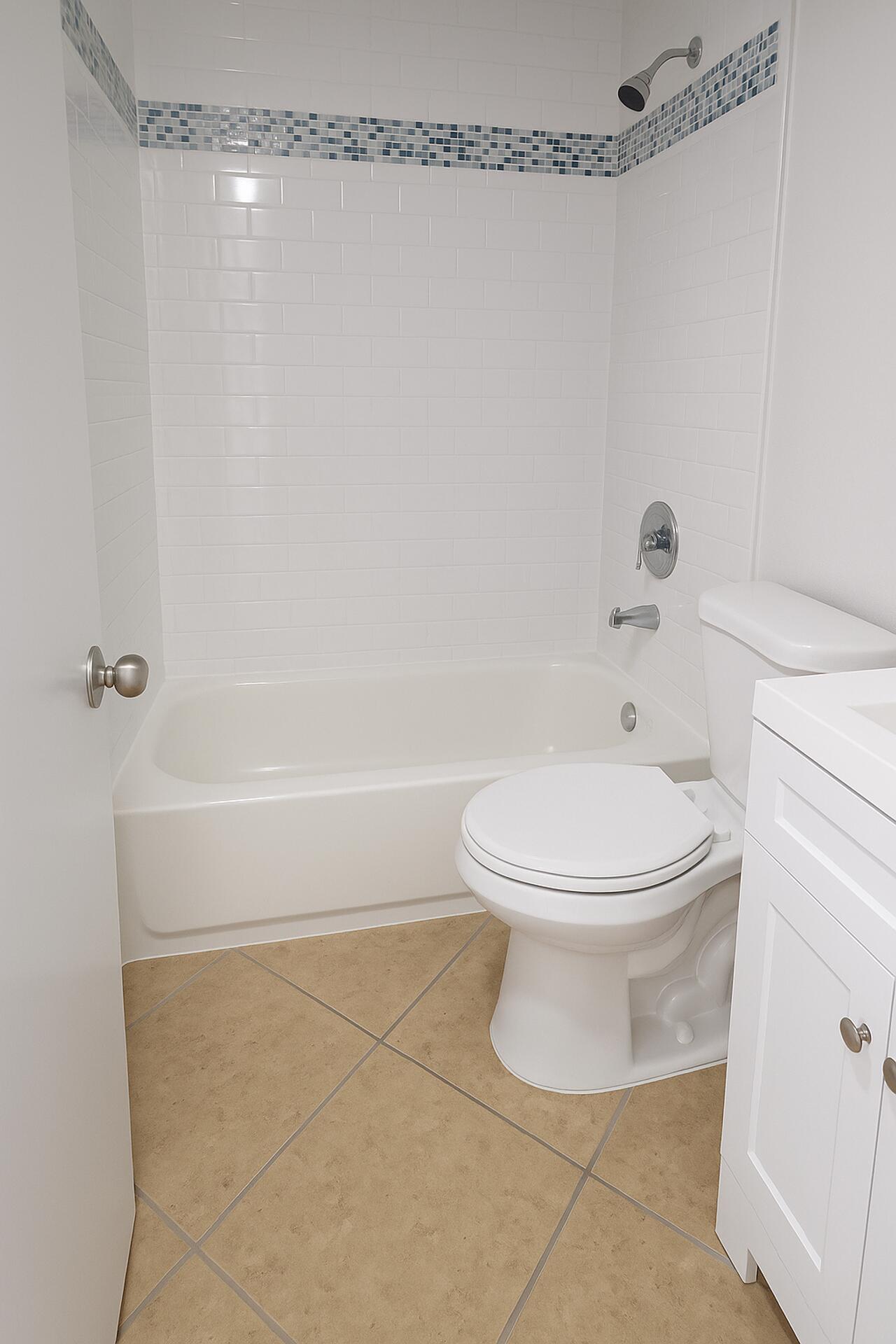 4670 Northeast 5th Avenue, Unit 1 Boca Raton, FL 33431 - Photo 7 of 8 a white toilet sitting next to a bath tub