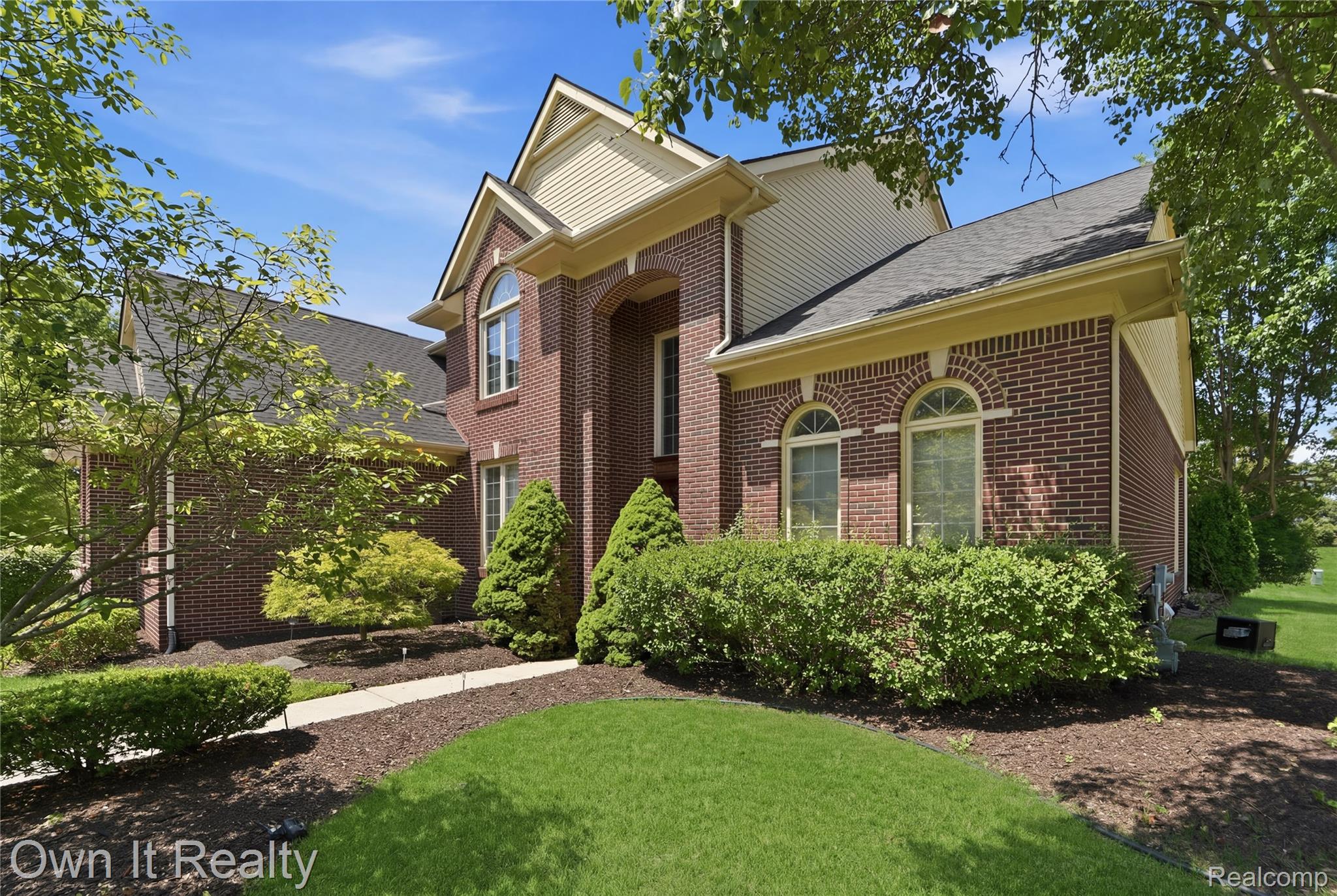 48280 Gladstone Road Canton, MI 48188 - Photo 5 of 59 Classic brick exterior with gabled roofline, arched windows, and light-colored soffits
