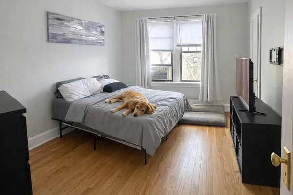 a bedroom with a bed and wooden floor