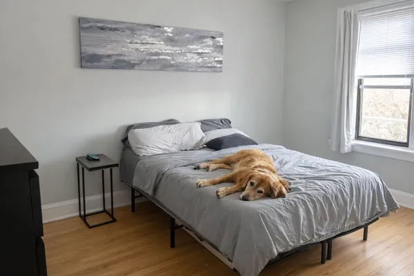 a bedroom with a bed and wooden floor