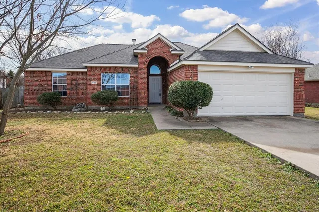 a view of a house with a yard and large tree