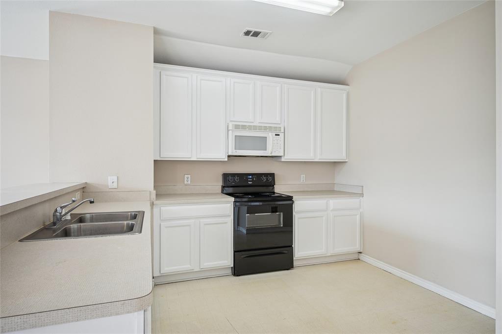 407 Autry Boulevard Gunter, TX 75058 - Photo 12 of 28 a kitchen with a stove top oven and cabinets