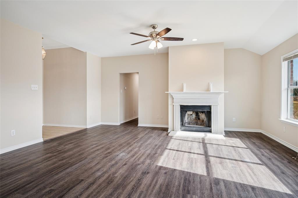 407 Autry Boulevard Gunter, TX 75058 - Photo 4 of 28 a view of an empty room with wooden floor fireplace and a window