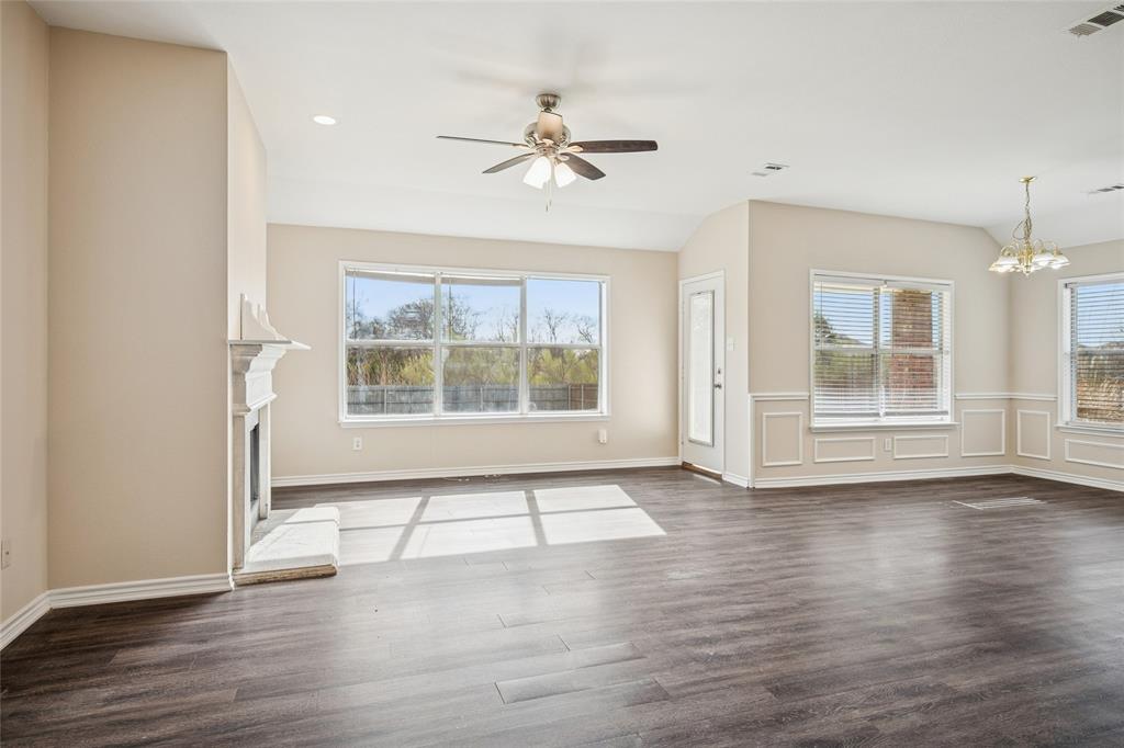 407 Autry Boulevard Gunter, TX 75058 - Photo 6 of 28 an empty room with wooden floor chandelier and windows