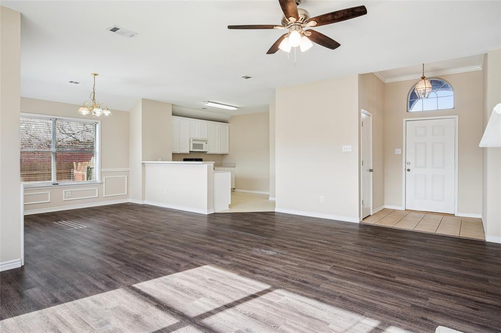 407 Autry Boulevard Gunter, TX 75058 - Photo 7 of 28 a view of a kitchen with wooden floor and a ceiling fan
