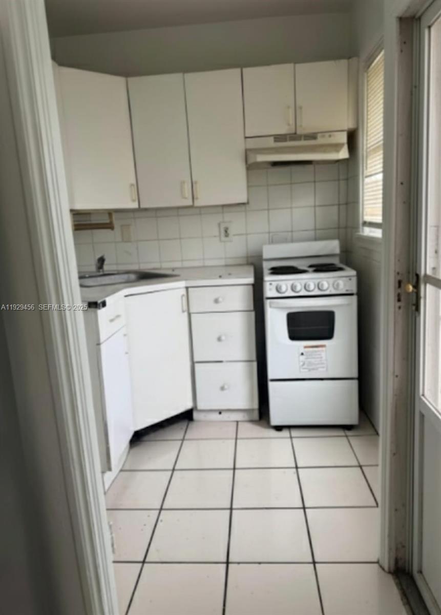 1820 Funston Street, Unit A Hollywood, FL 33020 - Photo 4 of 6 a kitchen with a stove sink and cabinets
