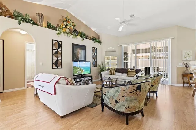 a living room with furniture kitchen view and a large window