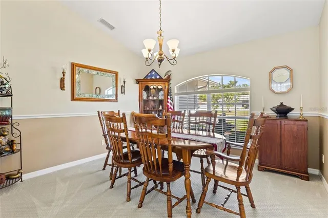 a view of a dining room with furniture a chandelier and wooden floor