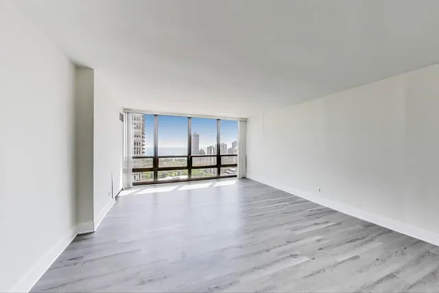 a view of empty room with wooden floor and cabinets