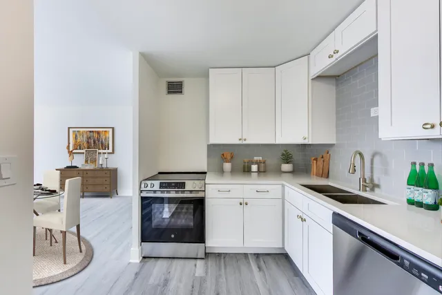 a kitchen with white cabinets and white appliances