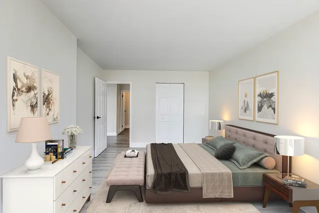 a view of an empty room with wooden floor and kitchen