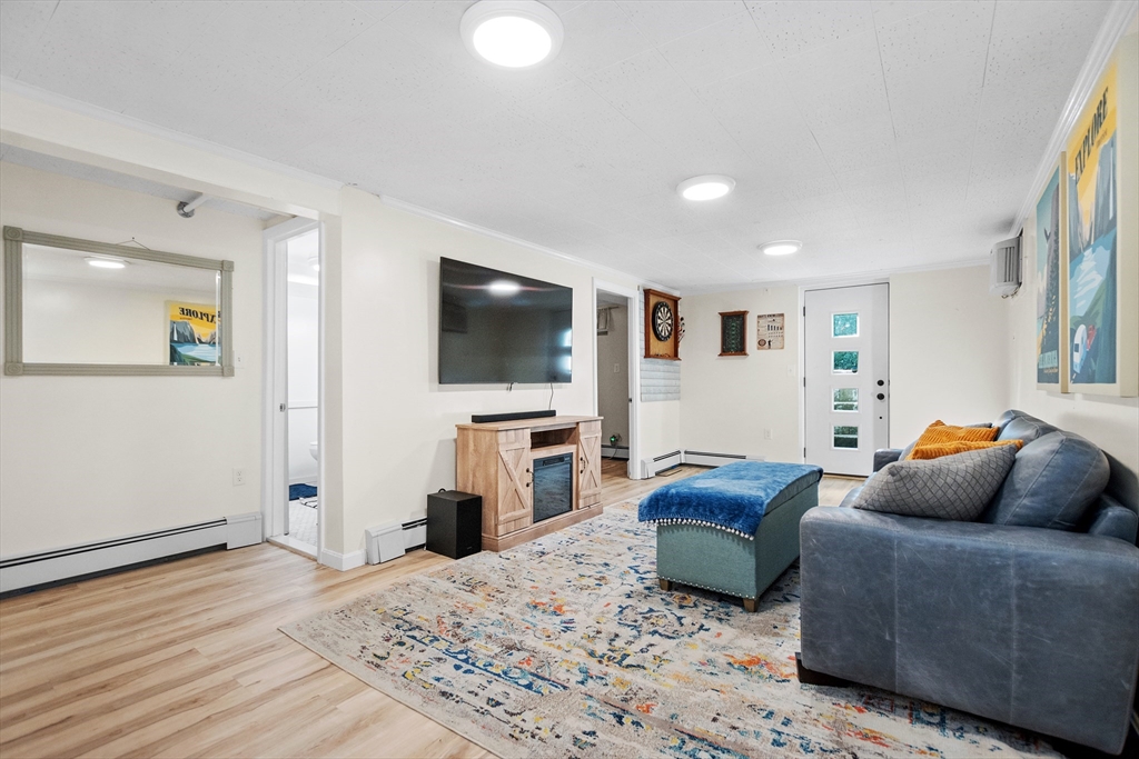 2 Lodge Road Natick, MA 01760 - Photo 24 of 36 a living room with a couch and a flat screen tv
