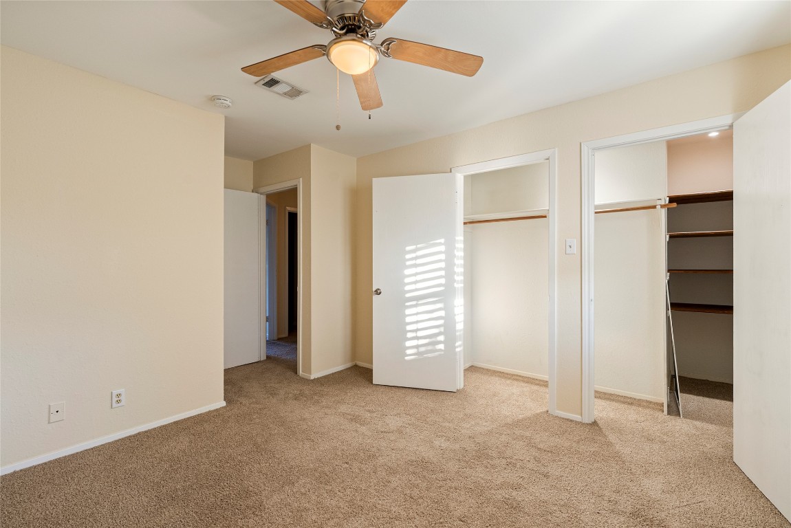 1408 Waterloo Trail, Unit A Austin, TX 78704 - Photo 12 of 13 Unfurnished bedroom with multiple closets, light carpet, and ceiling fan
