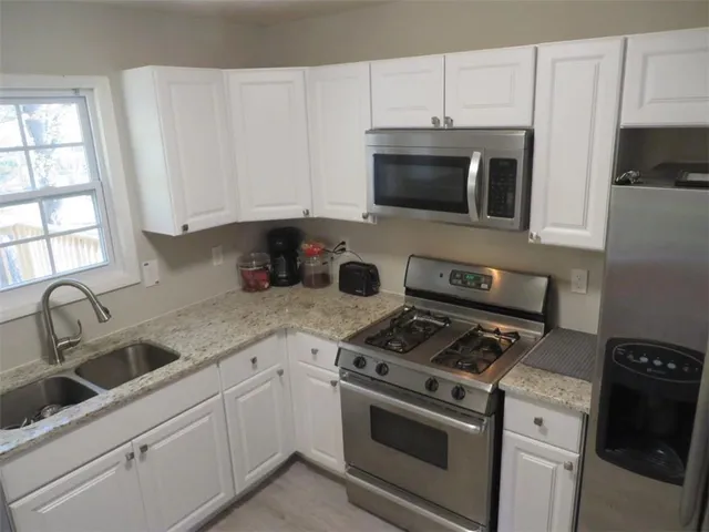 a kitchen with stainless steel appliances granite countertop a refrigerator sink and cabinets