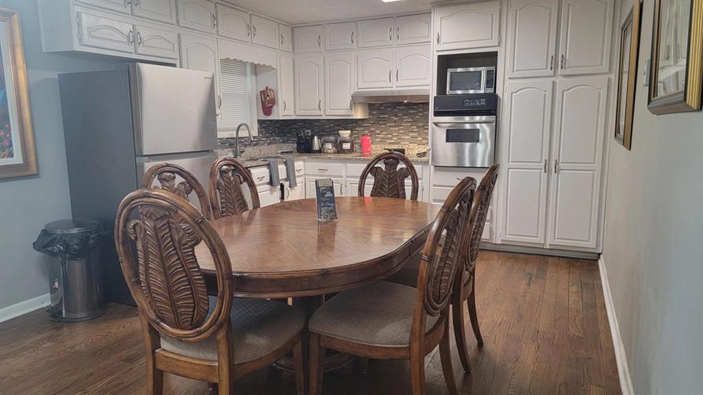3000 Creel Road Atlanta, GA 30349 - Photo 43 of 52 a kitchen with stainless steel appliances granite countertop a dining table chairs refrigerator and sink