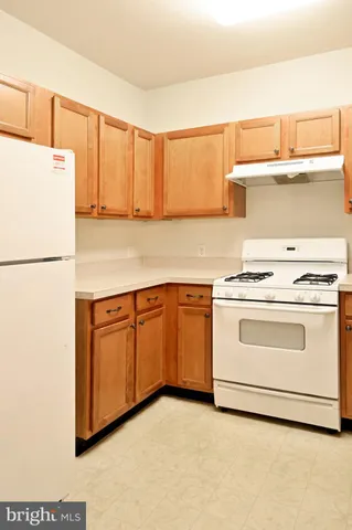 a kitchen with granite countertop a sink a stove and a refrigerator