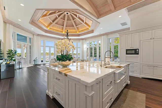 a spacious bedroom with a bed a chandelier and large window