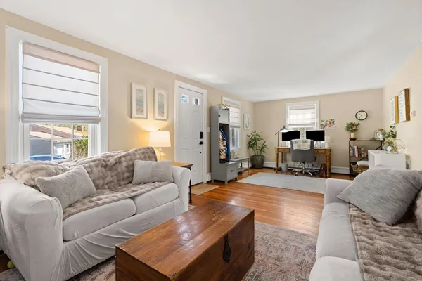 a living room with furniture and a wooden floor