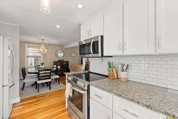 a kitchen with granite countertop a sink a stove and cabinets