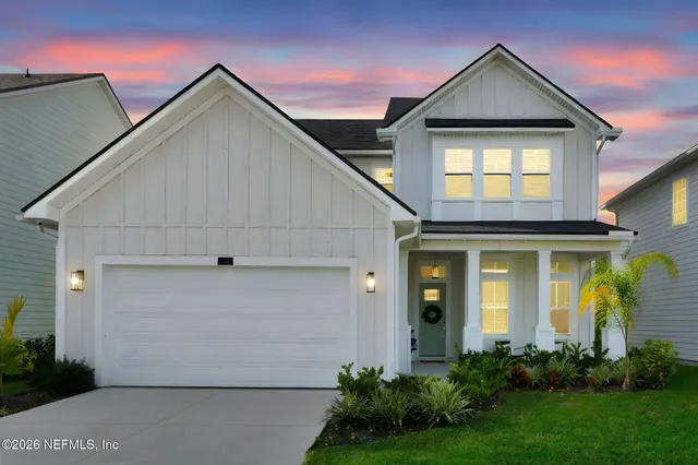 a view of a white house next to a yard