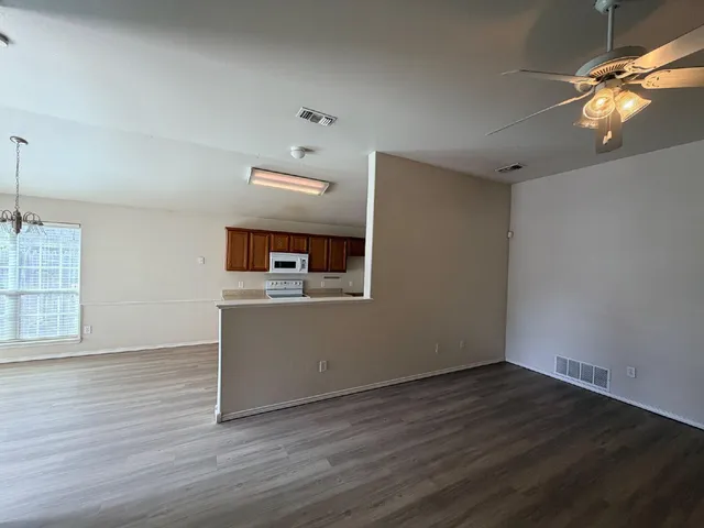 a view of a livingroom with wooden floor and a ceiling fan