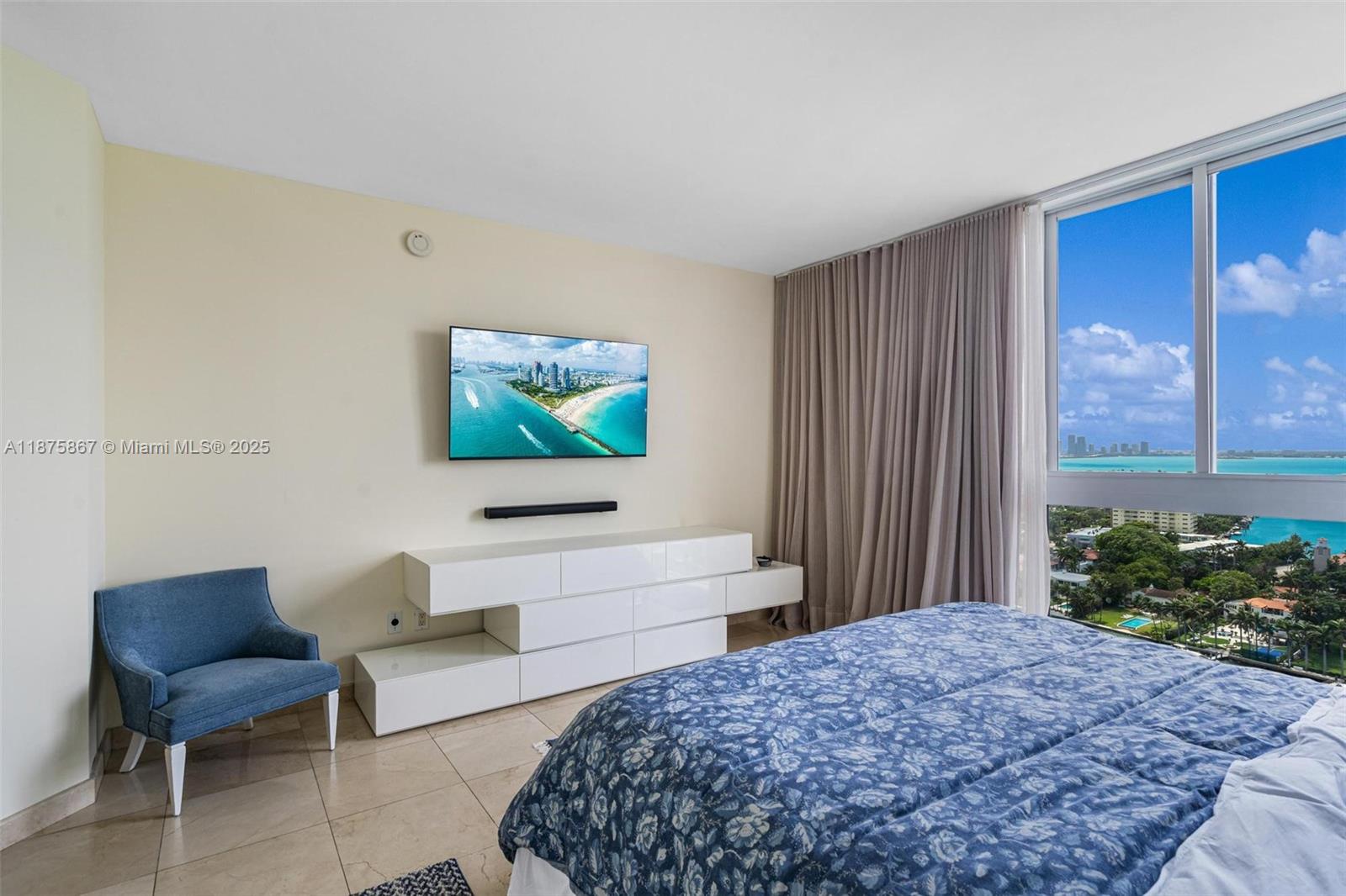 4779 Collins Avenue, Unit 2305 Miami Beach, FL 33140 - Photo 11 of 35 a bedroom with a bed and a flat screen tv