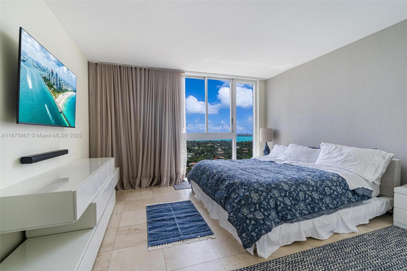 4779 Collins Avenue, Unit 2305 Miami Beach, FL 33140 - Photo 13 of 35 a bedroom with a bed and a flat screen tv