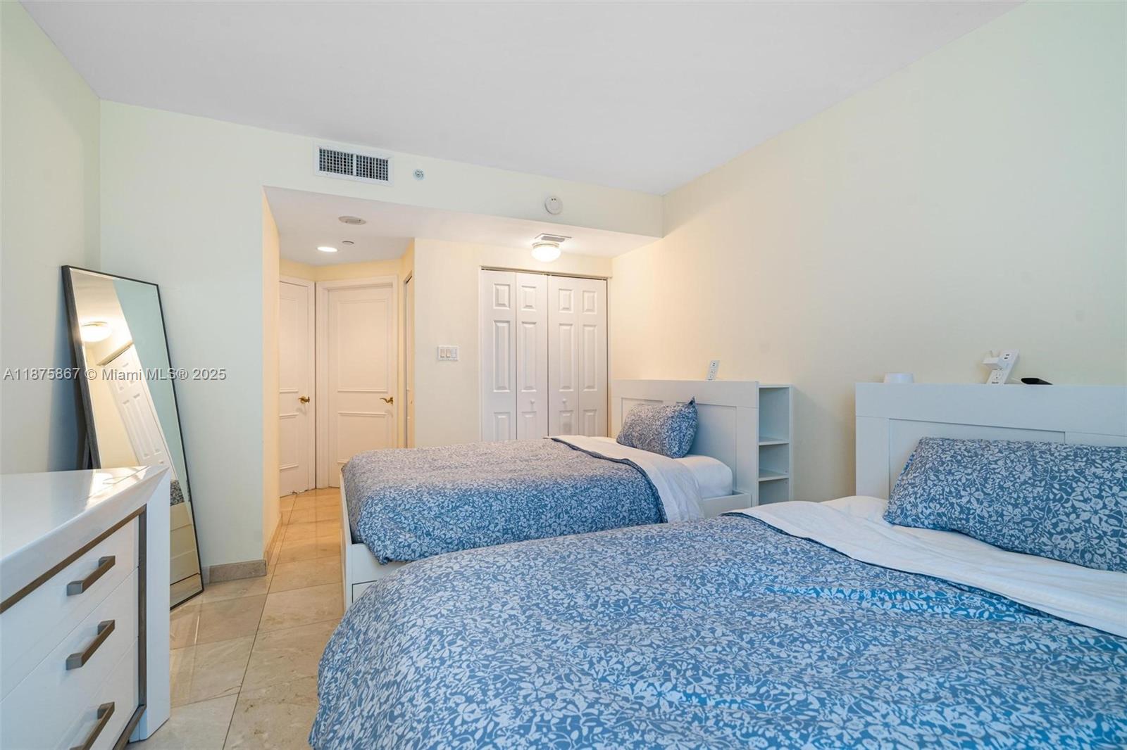 4779 Collins Avenue, Unit 2305 Miami Beach, FL 33140 - Photo 17 of 35 a spacious bedroom with a large bed and a dresser
