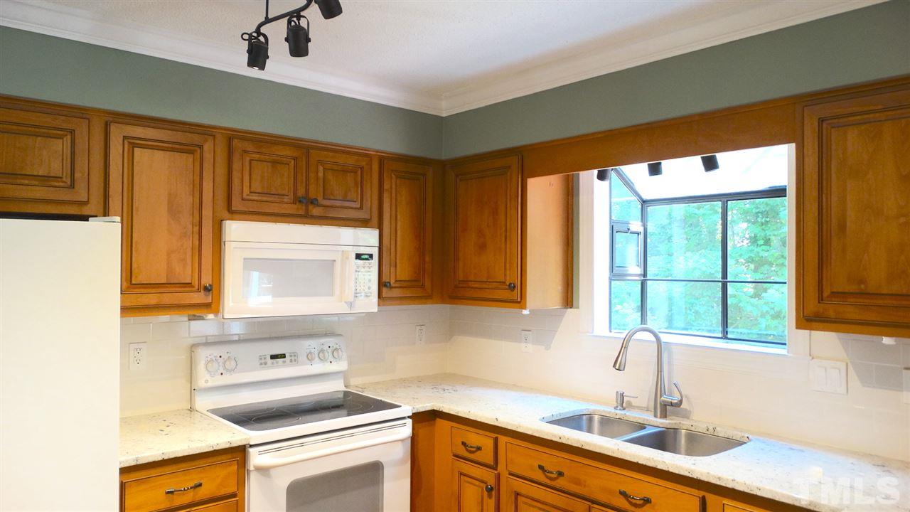 6812 Chasewick Circle Raleigh, NC 27615 - Photo 13 of 30 a kitchen with stainless steel appliances a sink a stove and a window