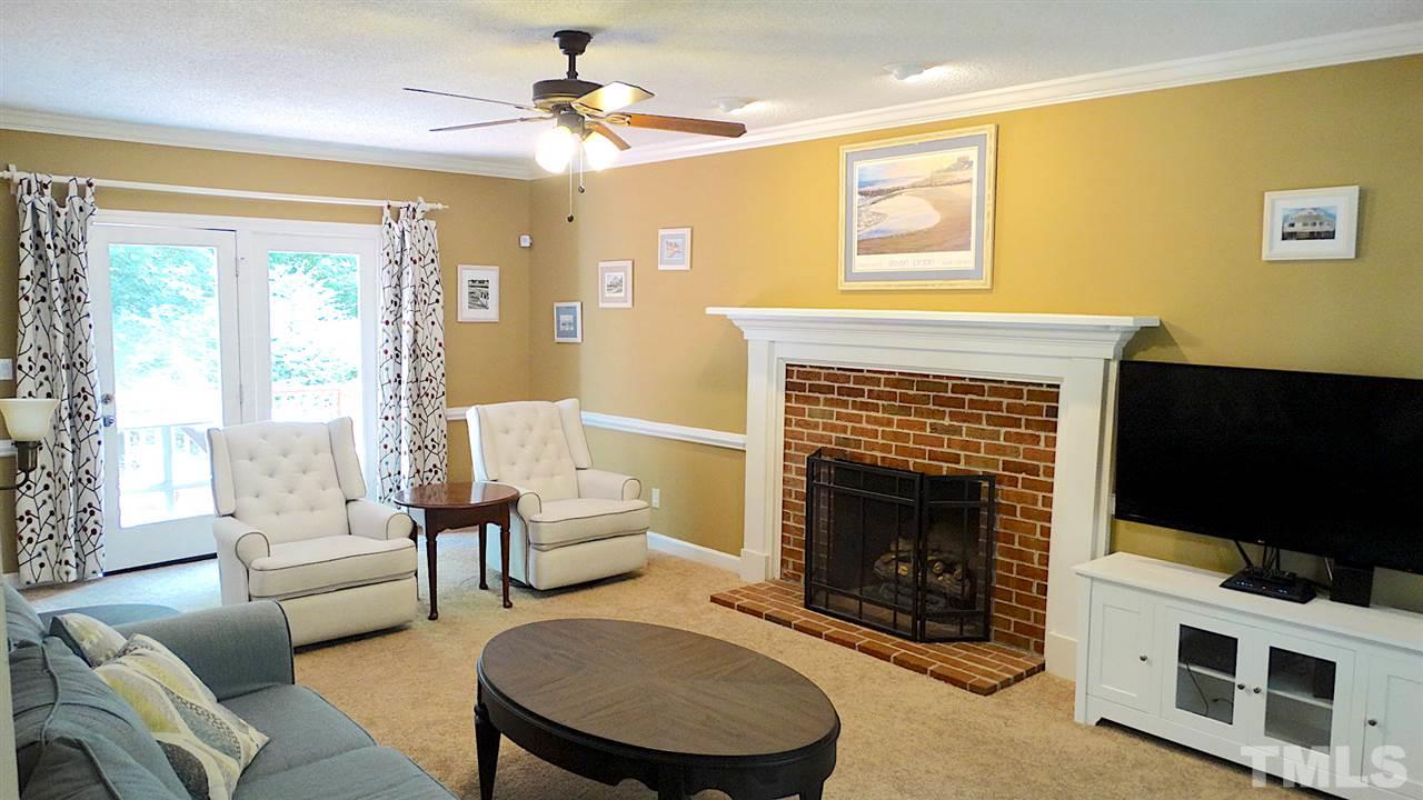 6812 Chasewick Circle Raleigh, NC 27615 - Photo 3 of 30 a living room with furniture a flat screen tv and a fireplace