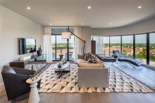 a living room with furniture large windows and a flat screen tv