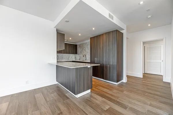 a kitchen with a sink cabinets and wooden floor