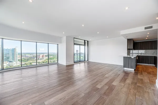 a view of empty room with wooden floor and fireplace