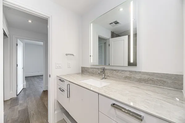 a bathroom with a granite countertop sink and mirror