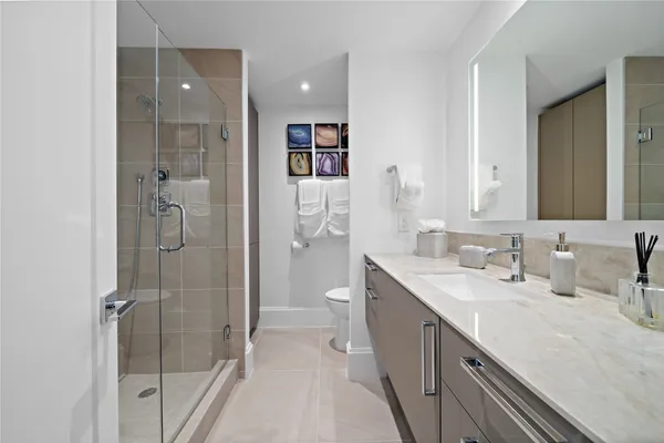 a spacious bathroom with a granite countertop sink a toilet and shower