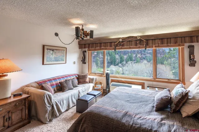 a bedroom with furniture and a large window