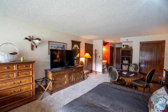 a living room with furniture a flat screen tv and dresser