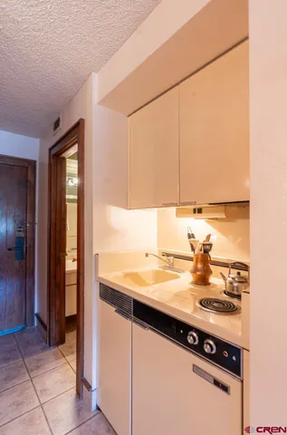 a kitchen with a sink a stove and cabinets