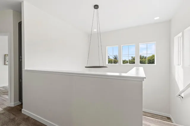 a view of a room with wooden floor and furniture
