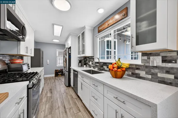 a kitchen with a sink a stove and cabinets