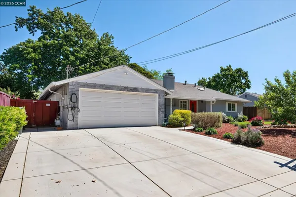 a front view of a house with a yard and potted plants