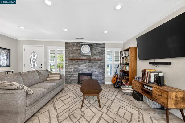 a living room with furniture a flat screen tv and a fireplace