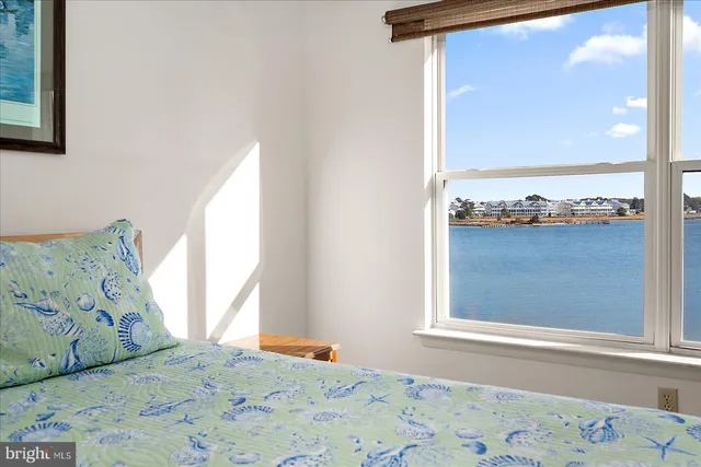 an aerial view of ocean and residential houses with outdoor space